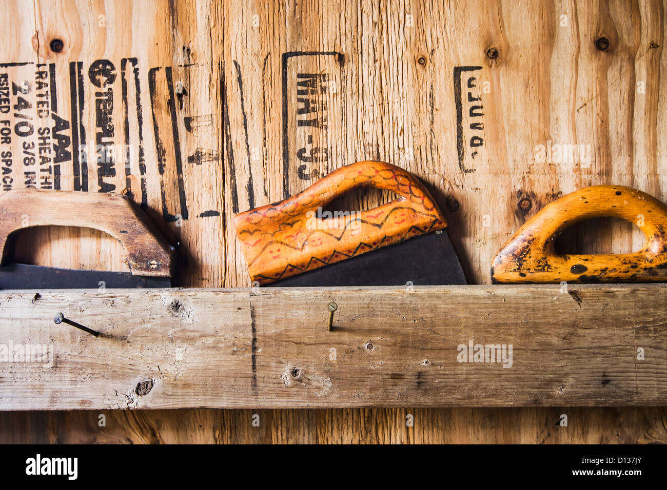 Tre coltelli ulu conservati dietro un bordo in una casa di fumo utilizzati per la sfilettatura e lo strippaggio di salmone di sussistenza;Bristol bay alaska Foto Stock