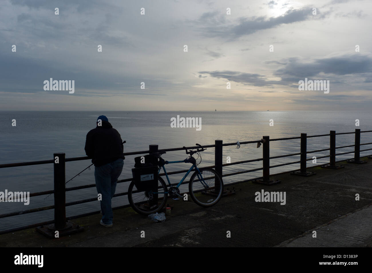 Il pescatore e la bicicletta, la mattina presto, silhouette Foto Stock