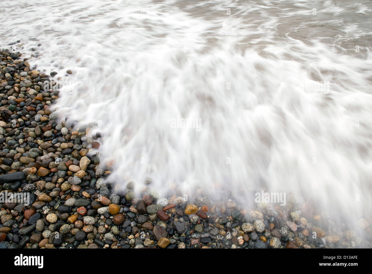 Lavaggio ad acqua su rocce sulla spiaggia. Foto Stock