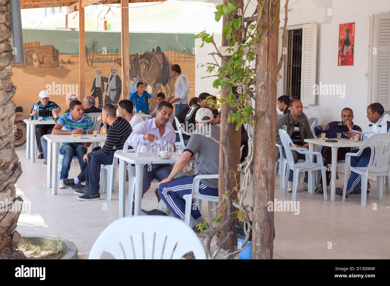 Della popolazione maschile è seduta in corrispondenza di un bordo strada cafe durante la siesta, Tunisia, Africa Foto Stock
