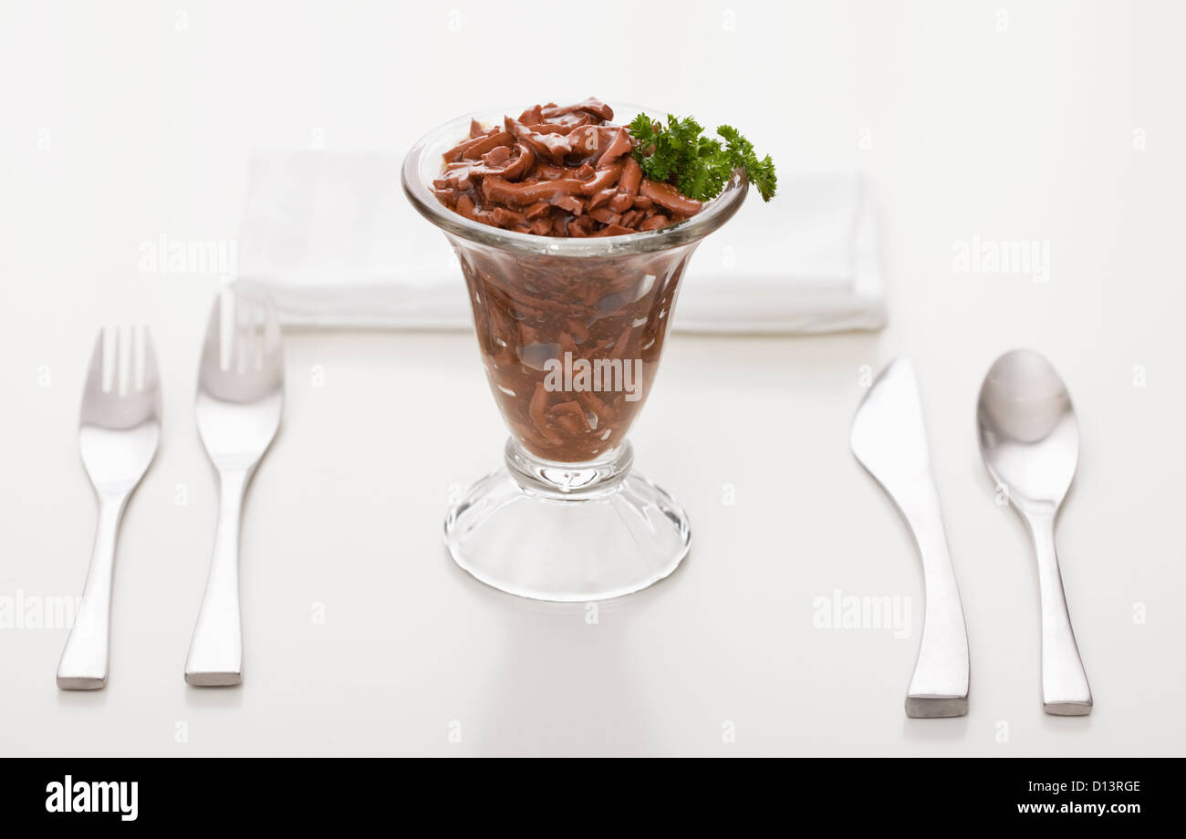 Alimenti per gatti in elegante bicchiere guarnito con prezzemolo Foto Stock