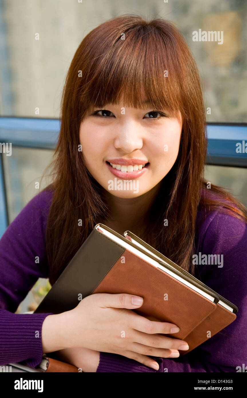 Asian studente di college ragazza con libro. Foto Stock