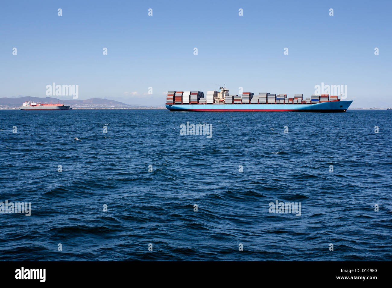 Foto di mare blu con una nave portacontainer la guida lungo l'orizzonte Foto Stock