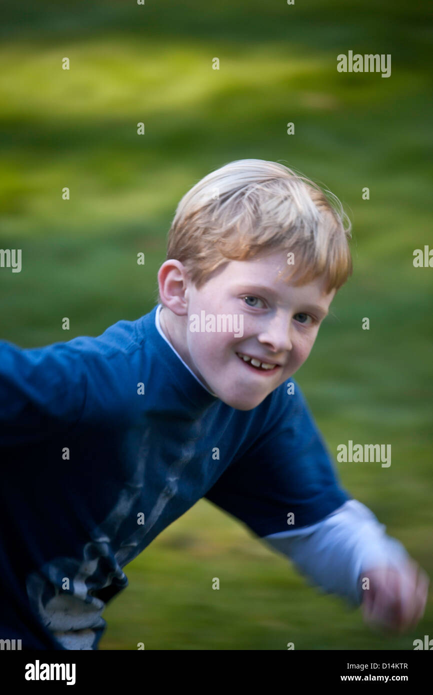Giovane ragazzo in esecuzione sul prato Foto Stock