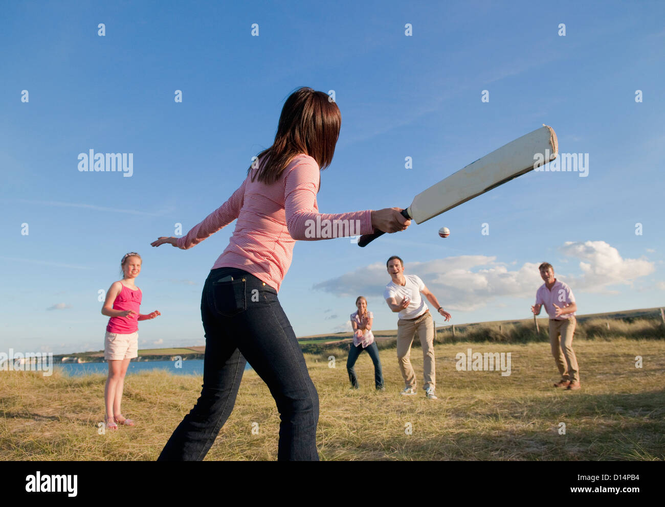 Famiglia giocare a cricket insieme all'aperto Foto Stock