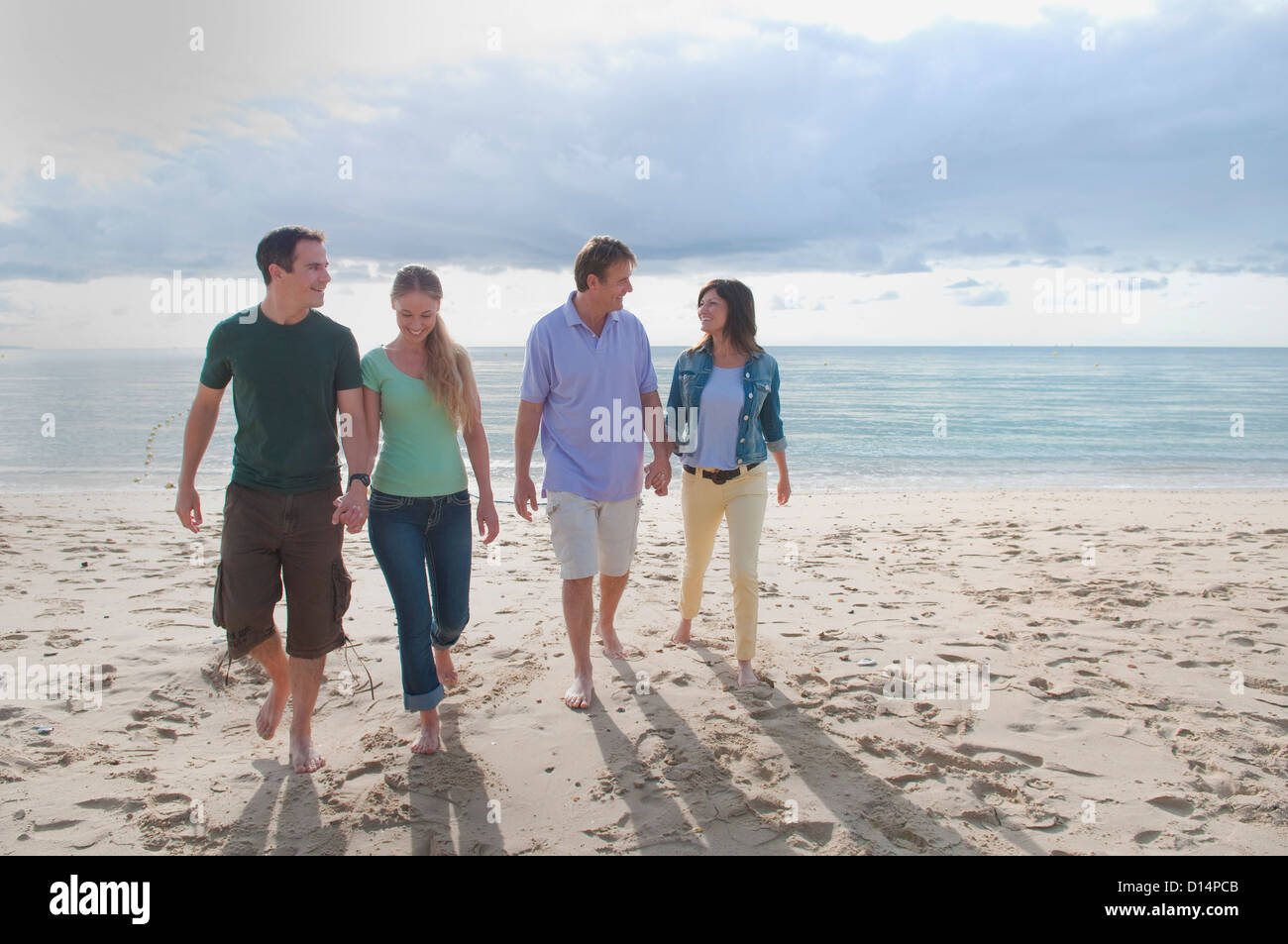 Le coppie tenendo le mani sulla spiaggia Foto Stock