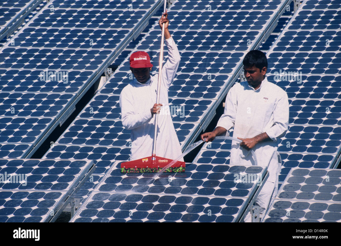 India Rajasthan, uomini pulire il pannello solare in Brahma Kumari Ashram in Mt. Abu, moduli solari a utilizzato per proprio la generazione di potenza Foto Stock