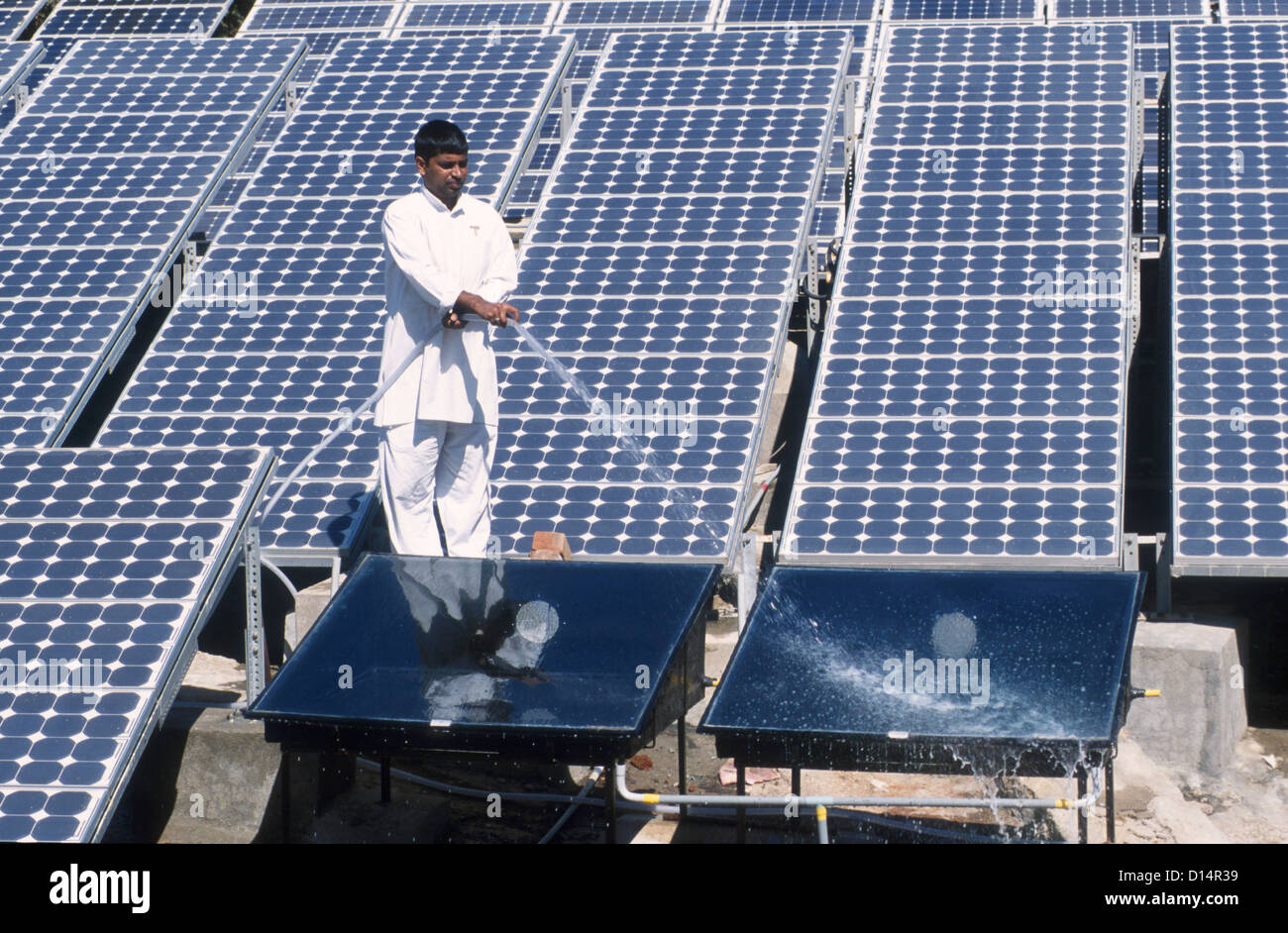 India Rajasthan, uomo pulire il collettore solare in Brahma Kumari Ashram in Mt. Abu, collettore solare è utilizzata per ottenere acqua riscaldata Foto Stock