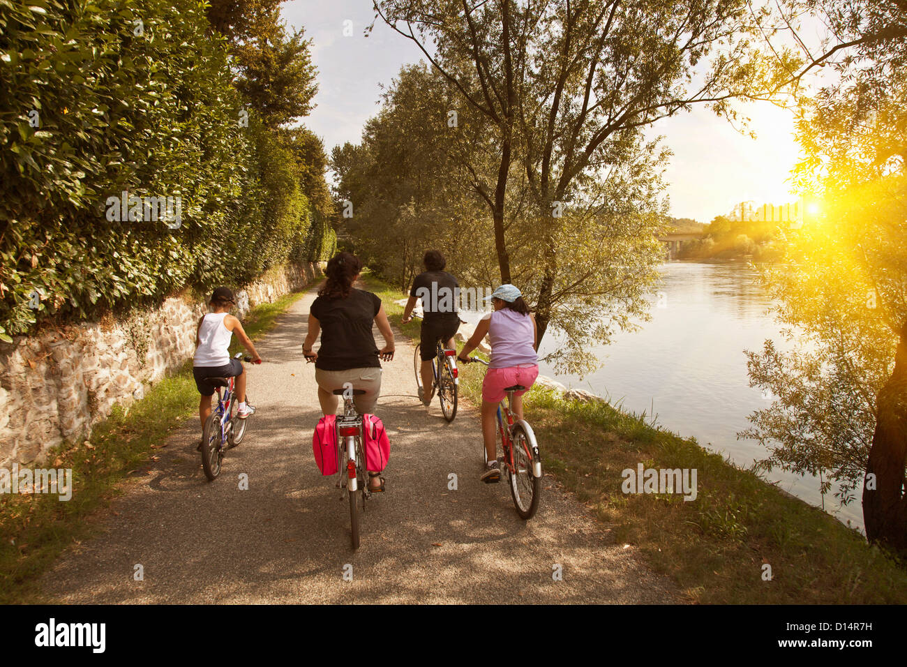 Famiglia equitazione biciclette da banca di fiume Foto Stock