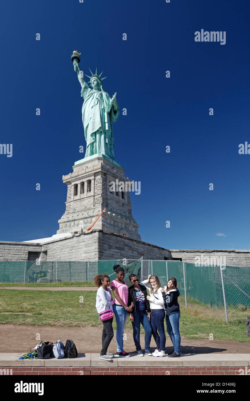 Le ragazze in posa davanti la statua della Libertà , Liberty Island, New York City Foto Stock