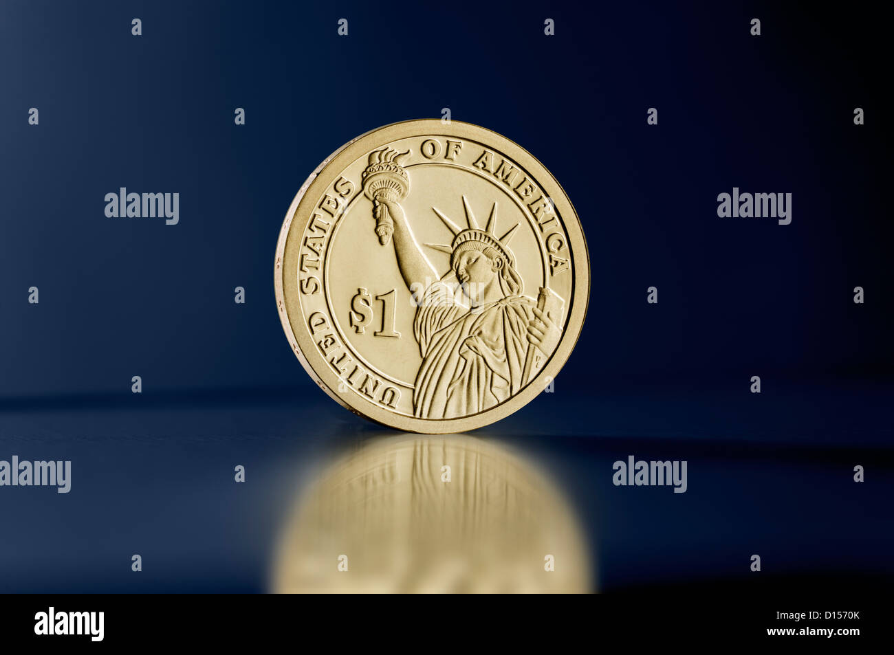 Statua della Libertà un dollaro moneta montante contro sfondo blu Foto Stock
