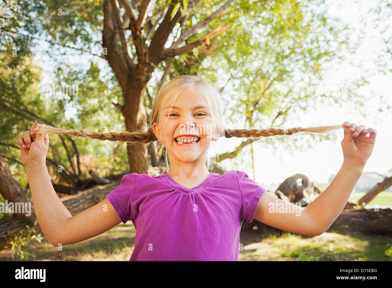 Stati Uniti d'America, Utah, Lehi, bambina (4-5) tenendo fuori il suo pig tail come lontano come lei può Foto Stock