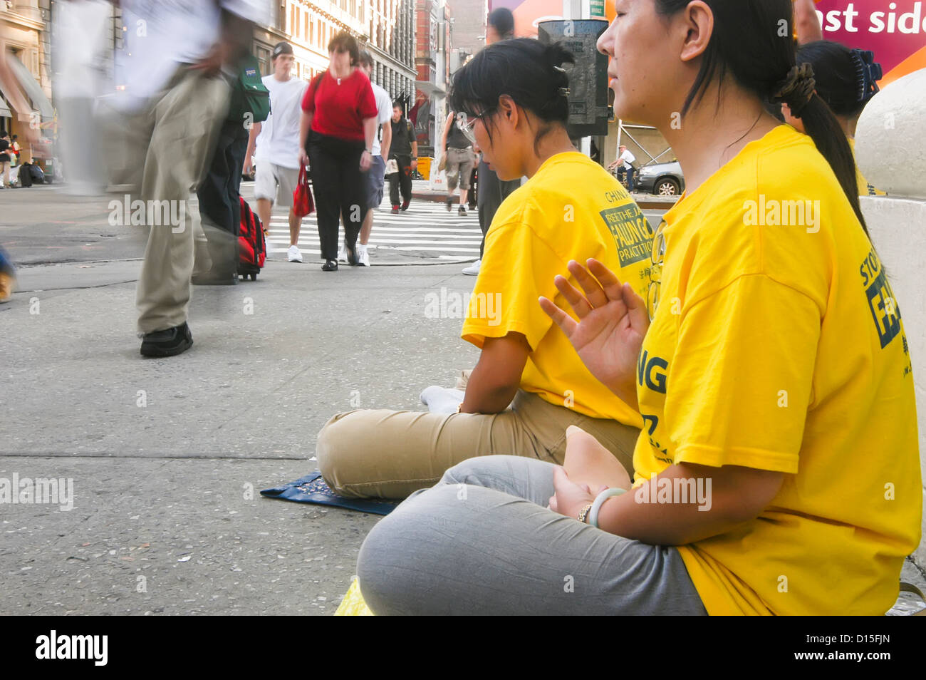 Un BUDDDHIST RISPOSTA ALLA GUERRA - Falun Gong (Falun Dafa) mediano nell'angolo di Houston Street e Broadway a New York City Foto Stock