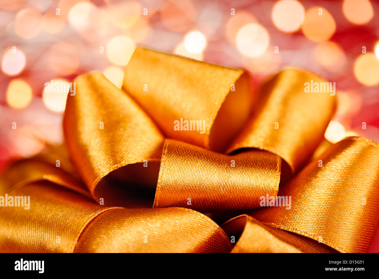 Golden regalo ribbon bow closeup con luci festive Foto Stock