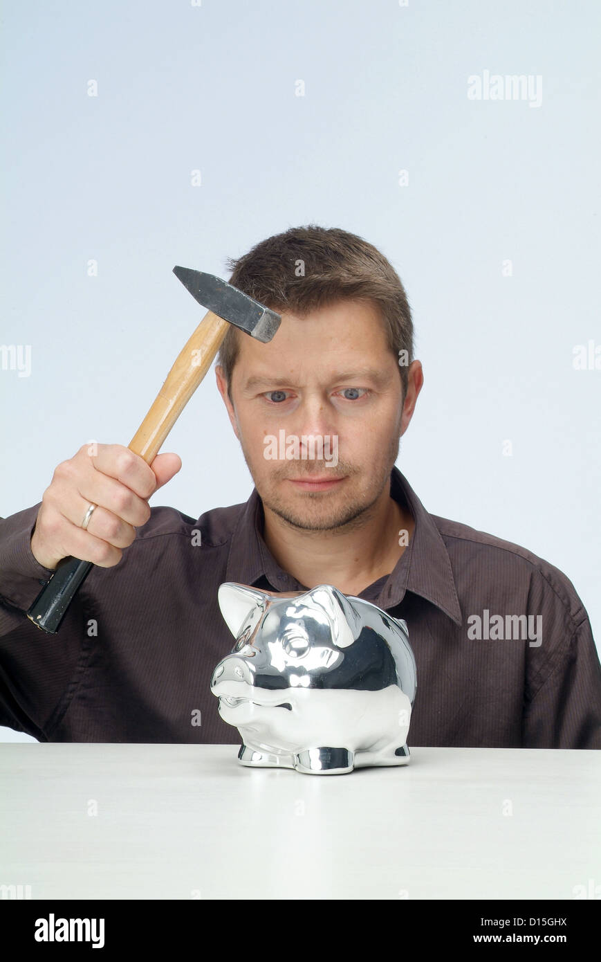 Amburgo, Germania, un uomo stragi il suo salvadanaio con un martello Foto Stock