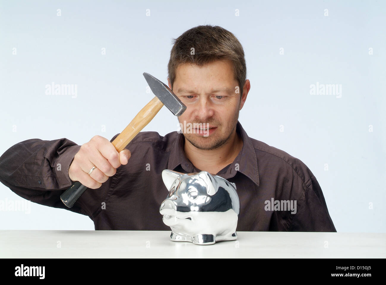 Amburgo, Germania, un uomo stragi il suo salvadanaio con un martello Foto Stock