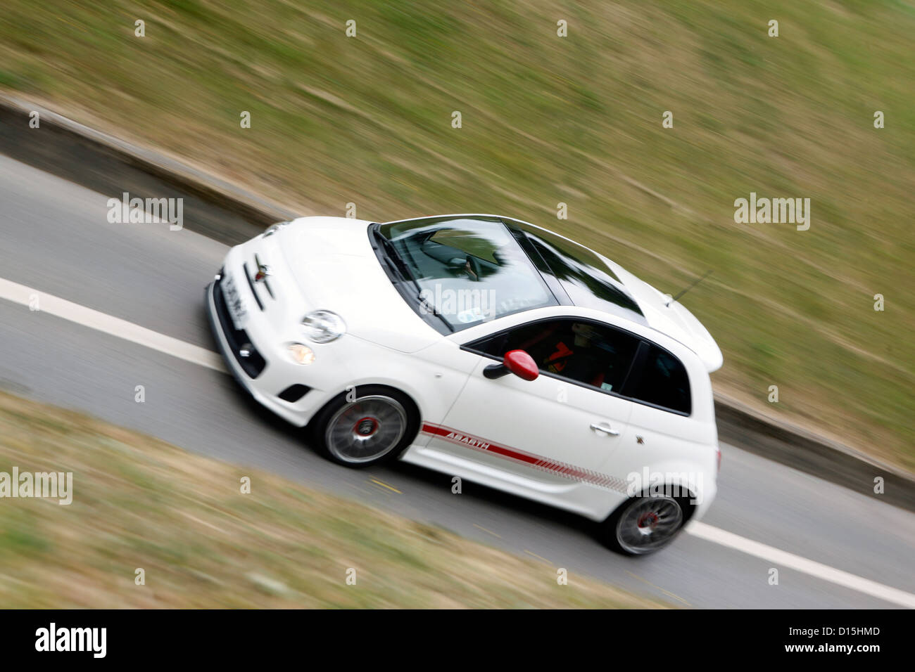 Un moderno e bianco Abarth Fiat 500 car guida veloce lungo una strada. Foto Stock