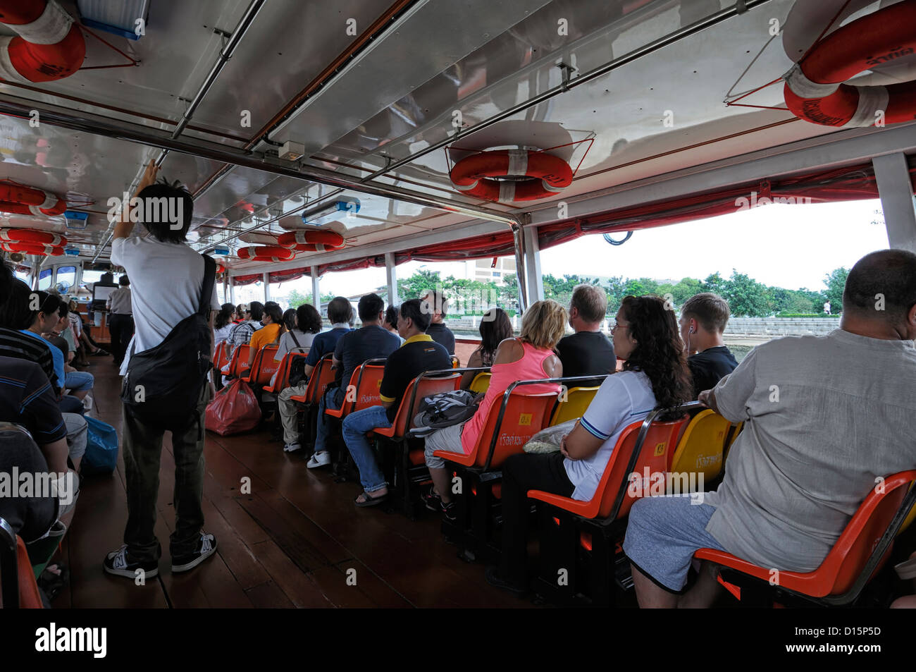 I turisti seduti seduti del Fiume Chao Praya express tour in barca per il giro turistico della città di Bangkok in Thailandia il trasporto di acqua Foto Stock