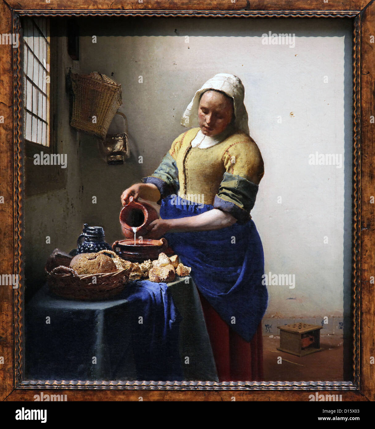 The Milkmaid (c. 1660) di Johannes Vermeer. Incorniciato il capolavoro del secolo d'oro olandese. Iconica scena domestica in olio. Foto Stock