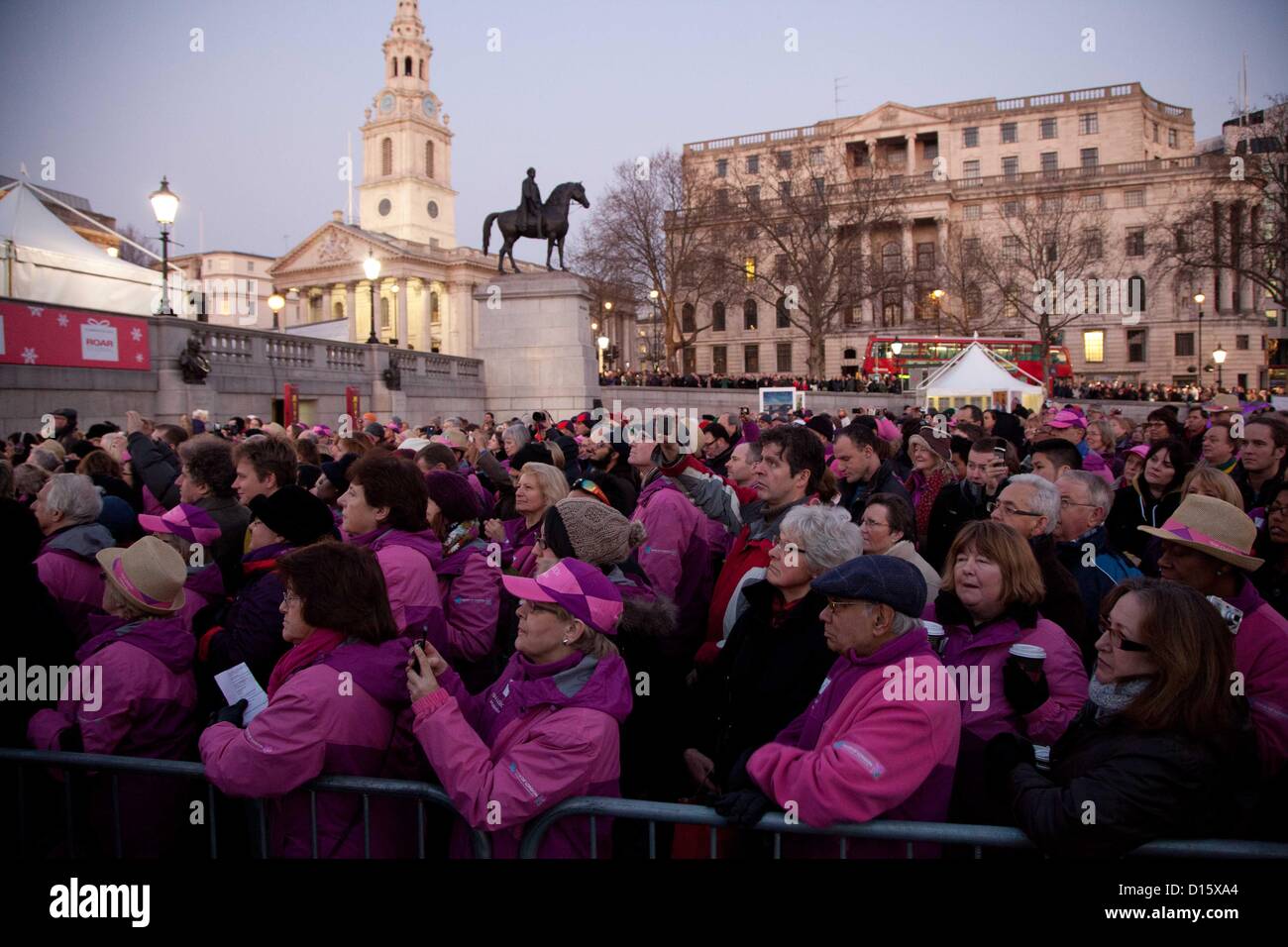 Londra, Regno Unito. 8 dicembre 2012 un pubblico di volontari, tra cui team di Ambasciatori di Londra, Londra 2012 giochi politici, gli ambasciatori di viaggio e altri volontari olimpici, guardare uno speciale concerto di carol in Trafalgar Square. Foto Stock