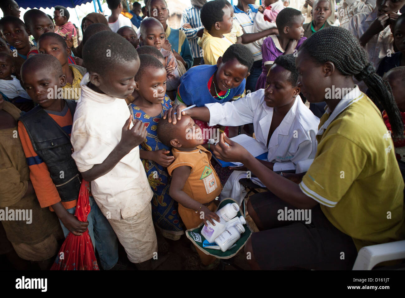 Bambini coda per farmaco vermifugo ad una immunizzazione Outreach Camp nel villaggio Kitugutu, Kyenjojo District, Uganda. Foto Stock