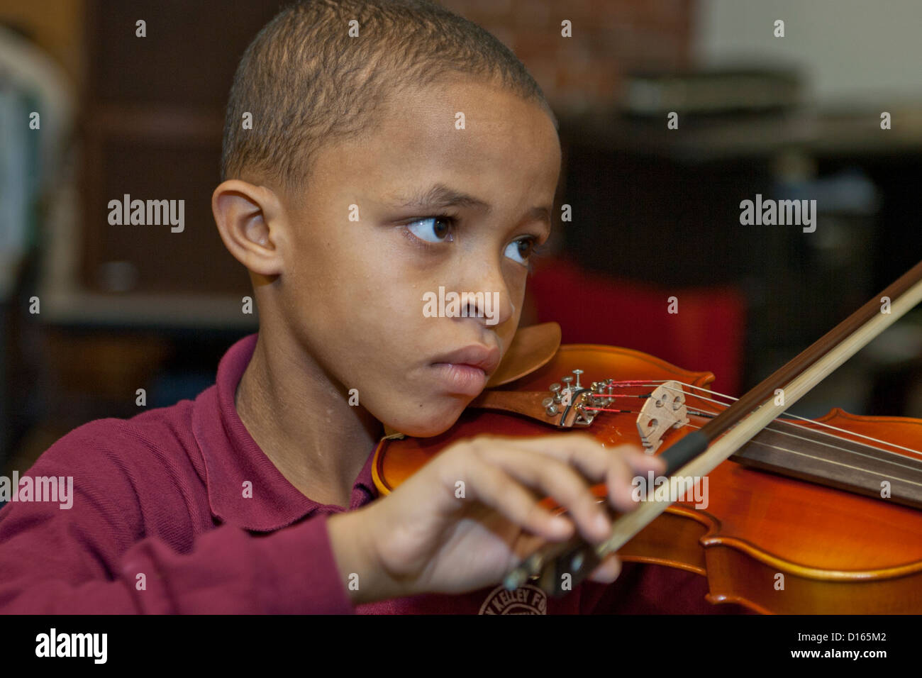 Ragazzo suona il violino nella classe di musica Foto Stock