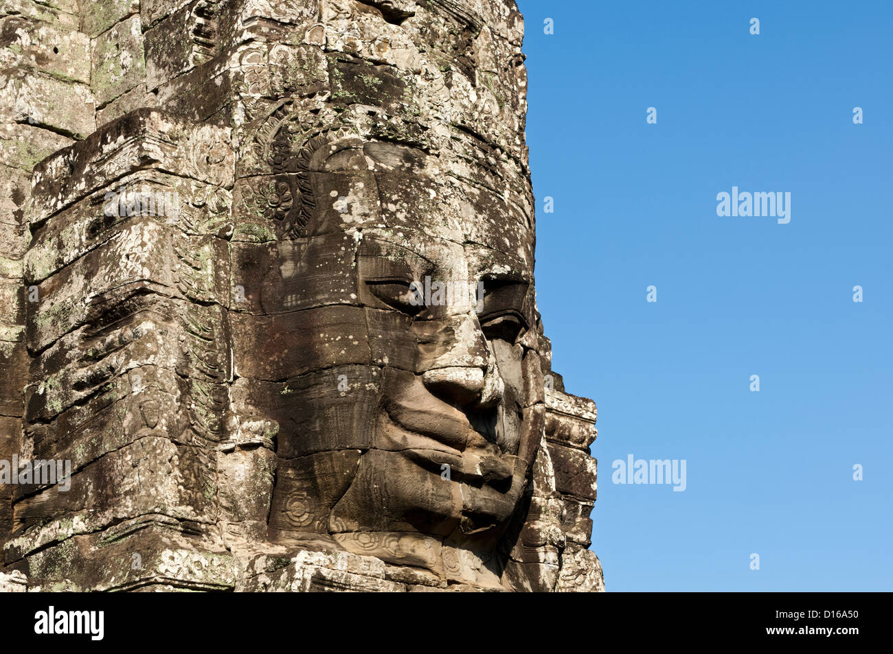 Faccia con un sorriso mistico scolpiti in pietra, tempio Bayon, Angkor Thom, Siem Reap, Cambogia Foto Stock