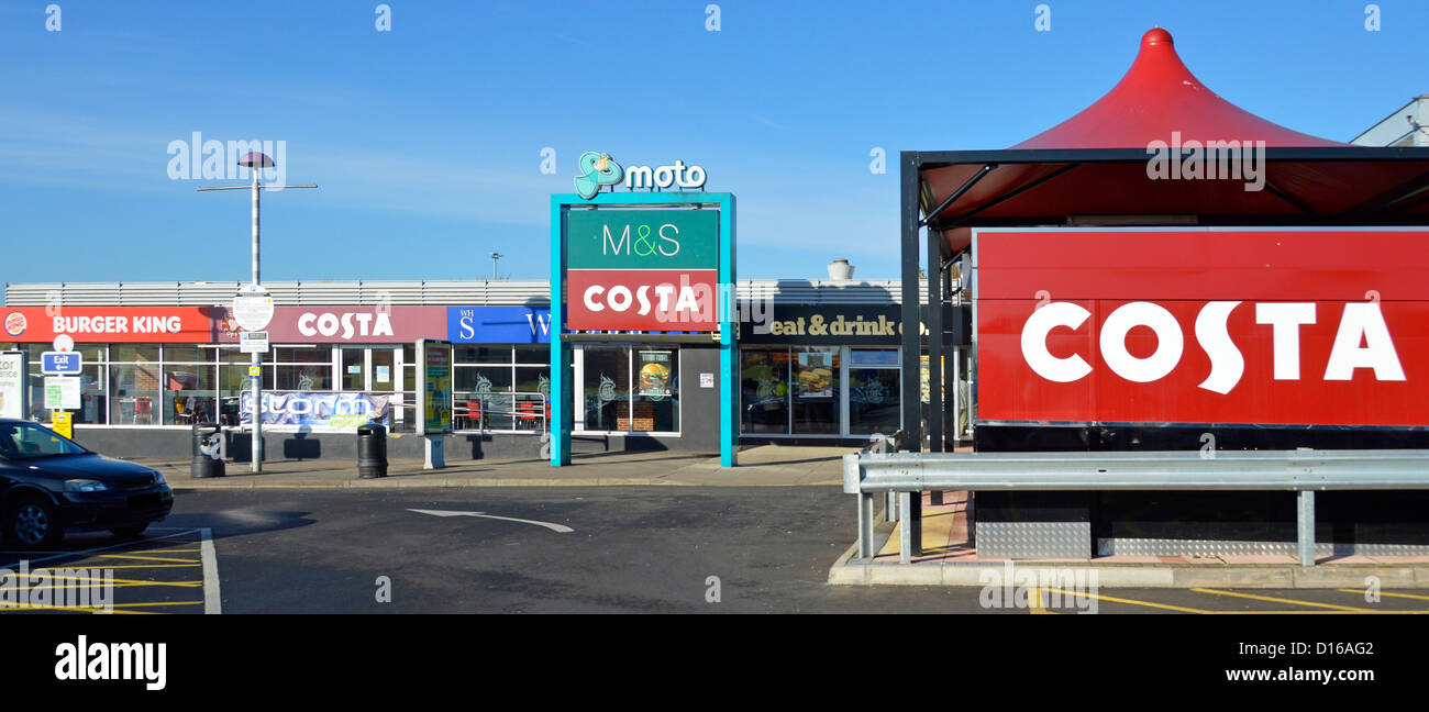 I cartelli del marchio Costa Coffee e i negozi del parcheggio della stazione di servizio autostradale gestito da Moto sulla M1 a Toddington Bedfordshire Inghilterra Regno Unito Foto Stock