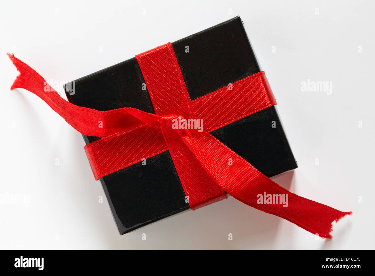 Confezione regalo nera con nastro rosso isolato su sfondo bianco Foto Stock