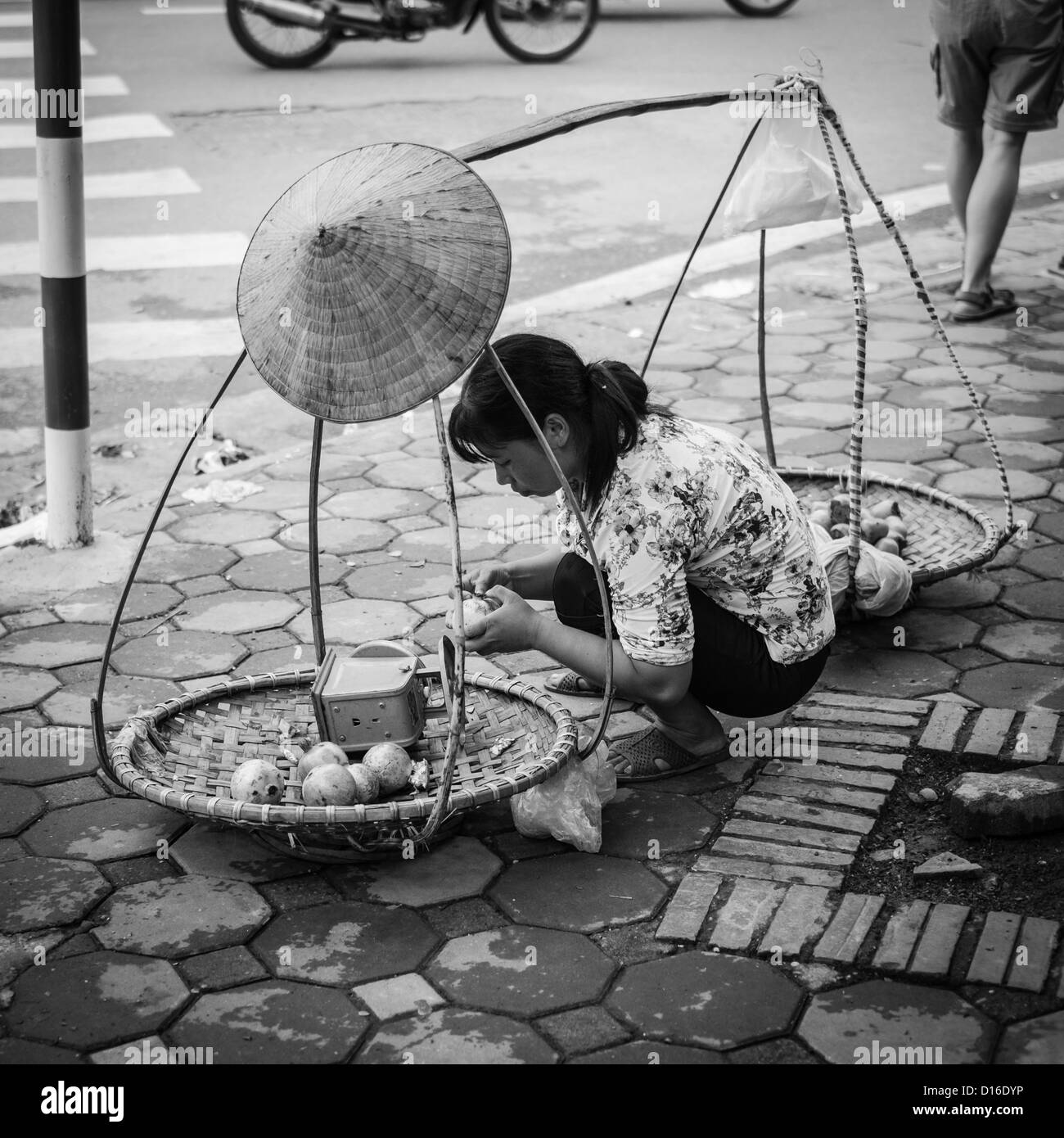 Femmina vietnamita al lavoro nella città vecchia di Hanoi e Foto Stock