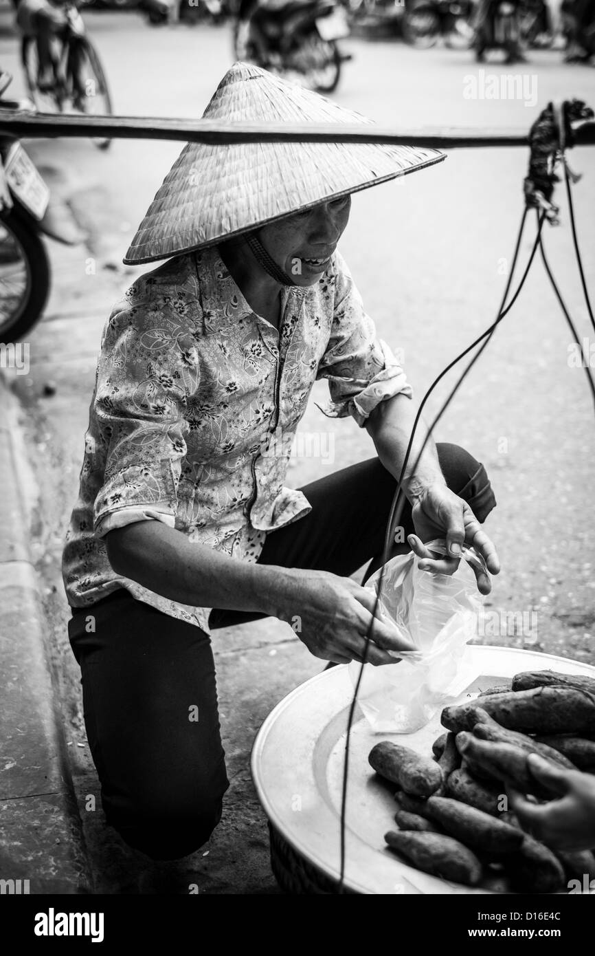 Femmina vietnamita al lavoro nella città vecchia di Hanoi e Foto Stock