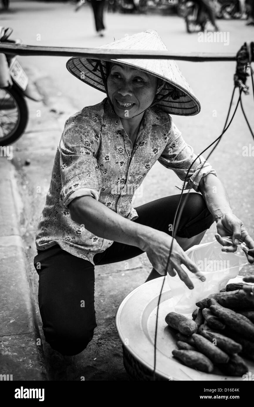 Femmina vietnamita al lavoro nella città vecchia di Hanoi e Foto Stock