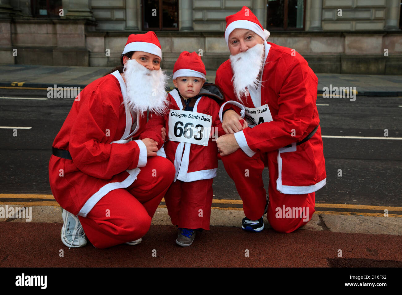 Domenica 9 dicembre 2012, Santa Dash carità Fun Run, George Square, Glasgow. Lewis Ramage, invecchiato 2 anni con sua madre Elaine Ramage 34 anni, e padre Stephen Ramage, di anni 44, tutti da Newton Mearns, Glasgow prima dell' inizio della Fun Run, sponsorizzato dal giornale Daily Record. Alamy Live News Foto Stock