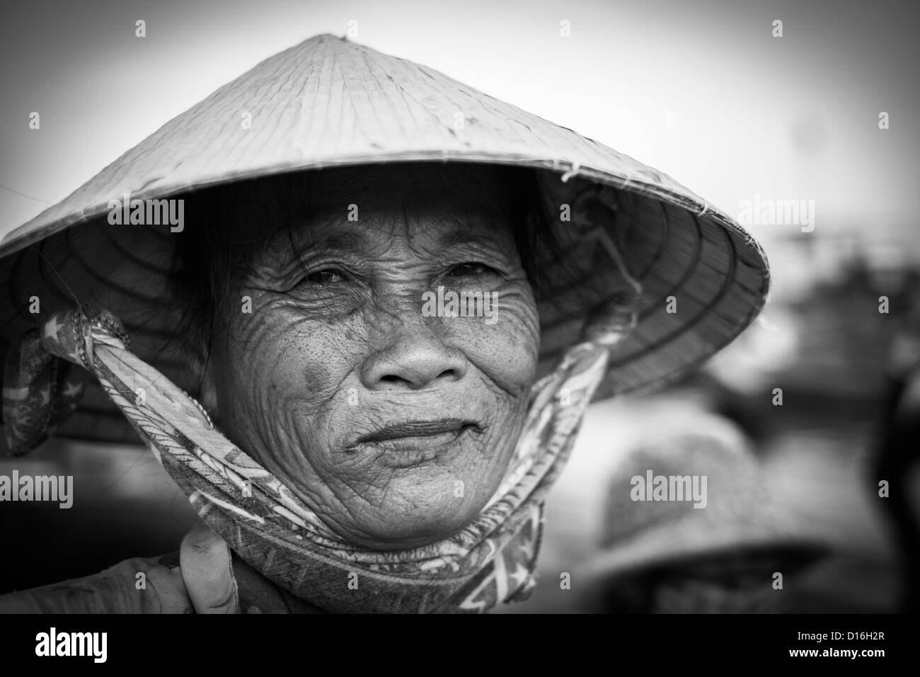 Bianco e nero ritratto di una donna vietnamita che indossa un tradizionale cappello di bambù Foto Stock