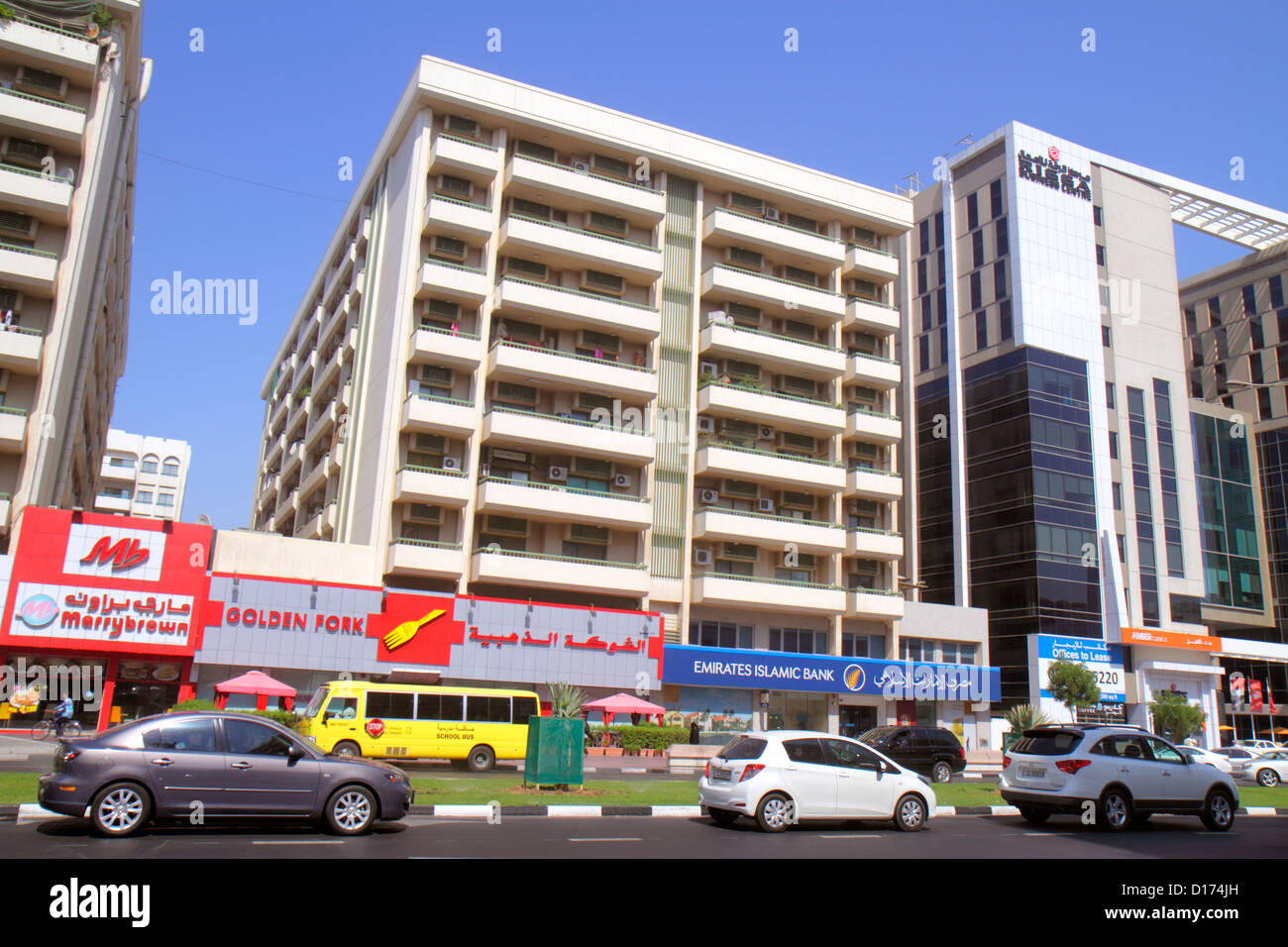 Dubai UAE,Emirati Arabi Uniti,Deira,al Rigga,al Maktoum Road,Street scene,business,quartiere,edifici,skyline della città,scuolabus,pullman,inglese,arabo, Foto Stock