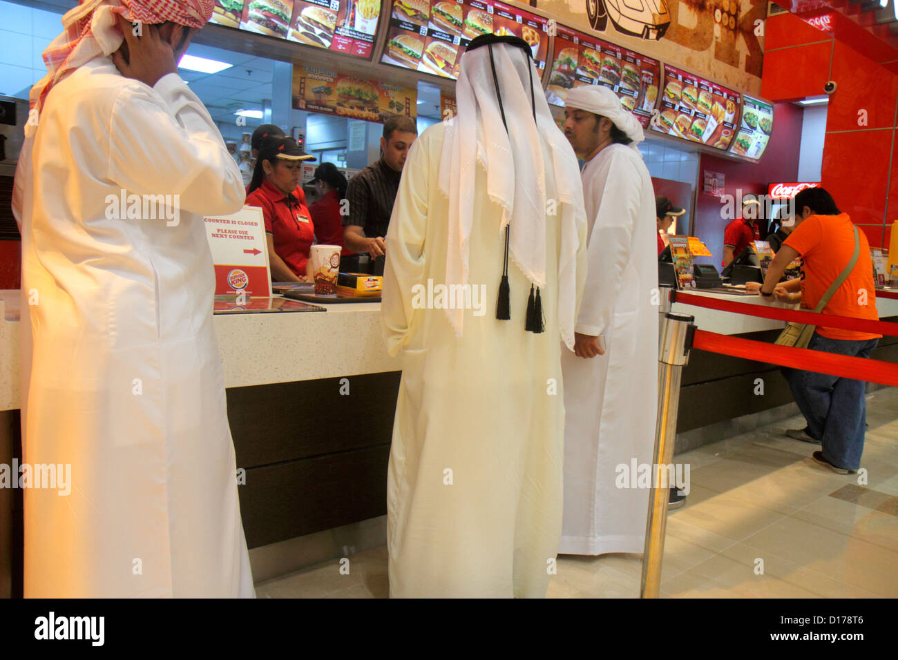 Dubai UAE,Emirati Arabi Uniti,Downtown Dubai,Dubai Mall,food Court plaza,Musulmani,Bedouin,uomini musulmani etnici maschi adulti,scialle,accappatoio,keffiyeh,B Foto Stock