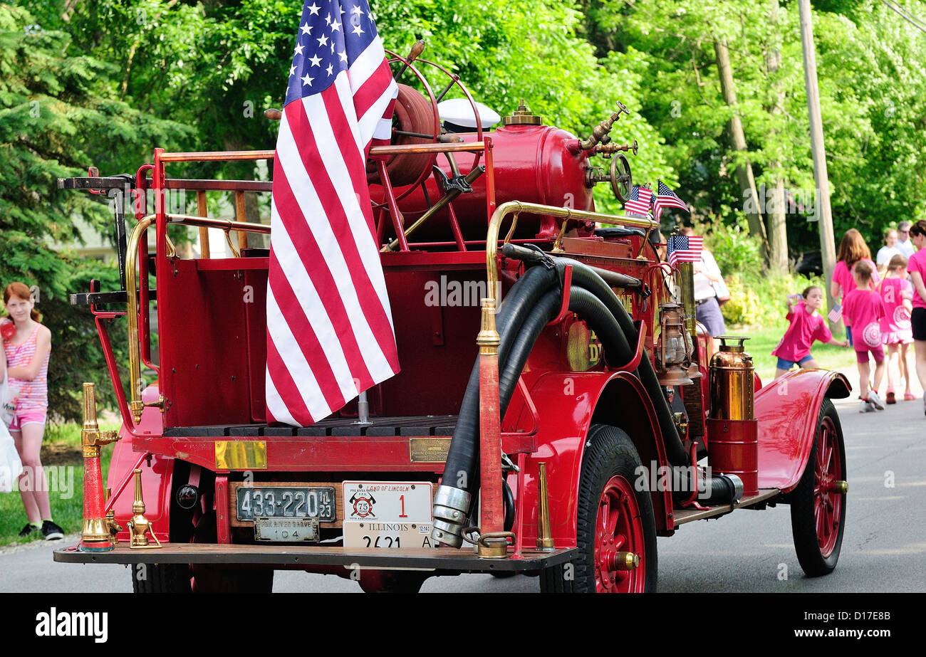 Antique firetruck adornata con bandierine americane partecipando in una piccola città memorial day parade su Main Street USA. Foto Stock
