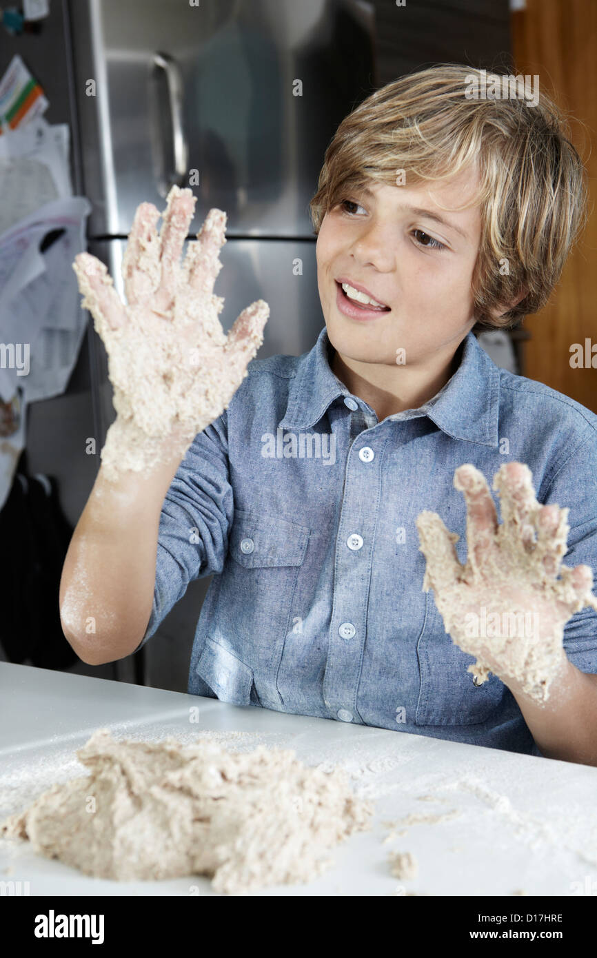 Ragazzo esaminando le mani appiccicose in cucina Foto stock - Alamy