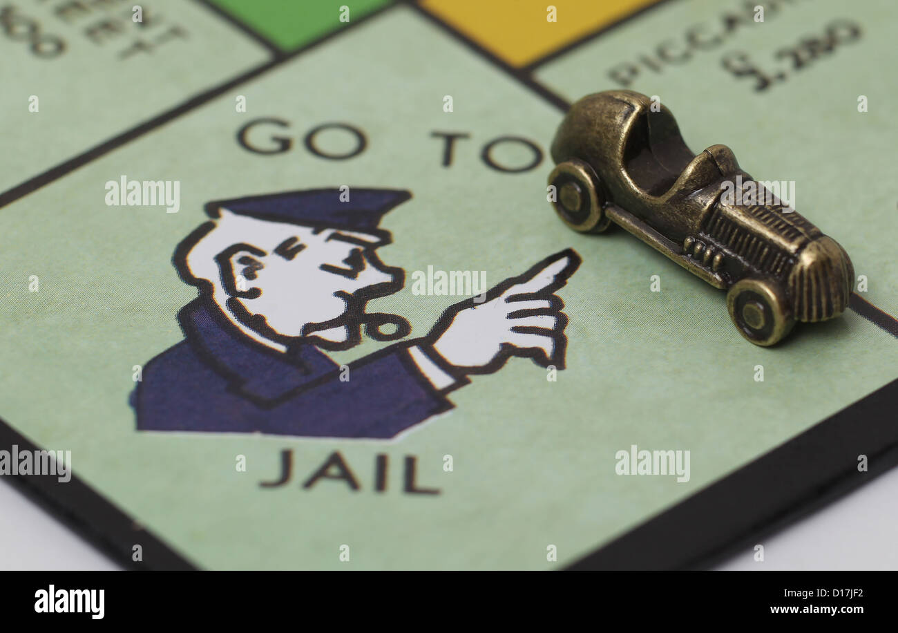 Per andare in prigione quadrato su una scheda di monopolio con giocatori auto pezzo. Foto Stock