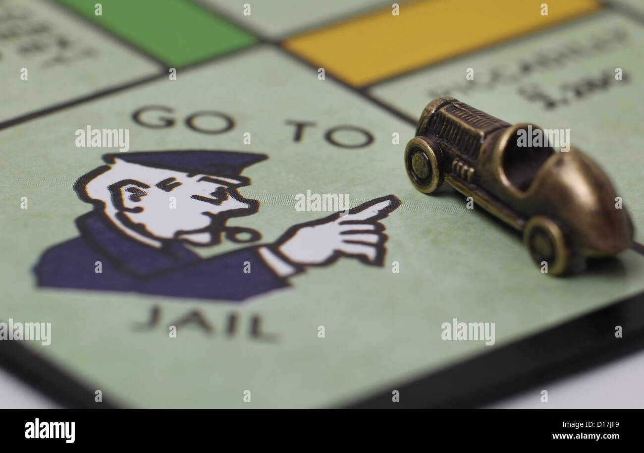 Per andare in prigione quadrato su una scheda di monopolio con giocatori auto pezzo. Foto Stock