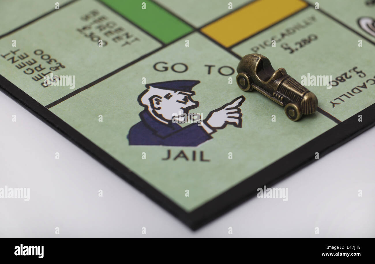 Per andare in prigione quadrato su una scheda di monopolio con giocatori auto pezzo. Foto Stock