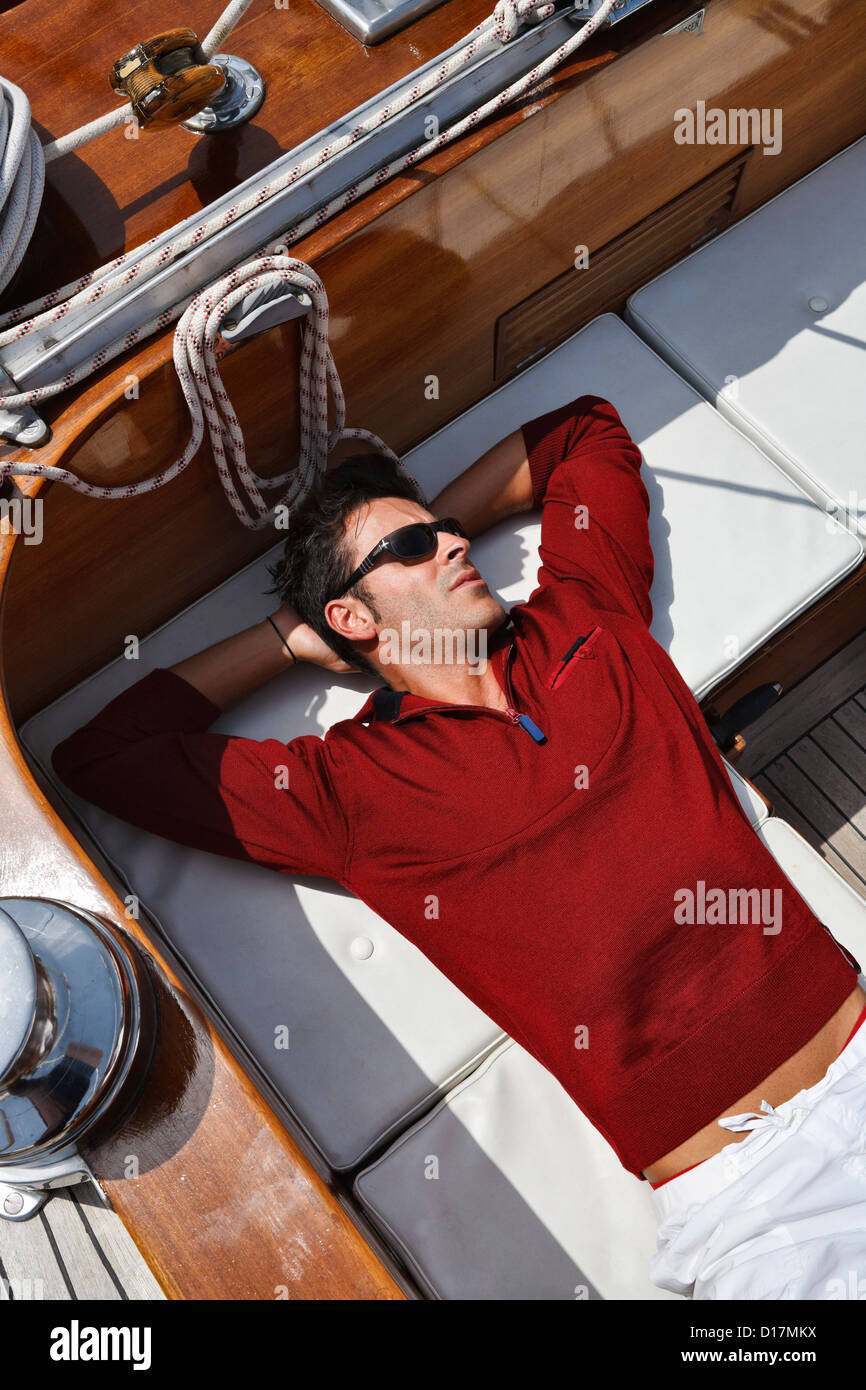 L'Italia, Toscana, giovane marinaio è in appoggio su una tavola di legno barca a vela Foto Stock