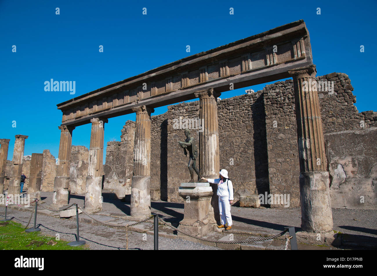 Tourist posa vicino ad una statua Pompei la città romana sepolta nella lava vicino a Napoli in la regione Campania sud Italia Europa Foto Stock