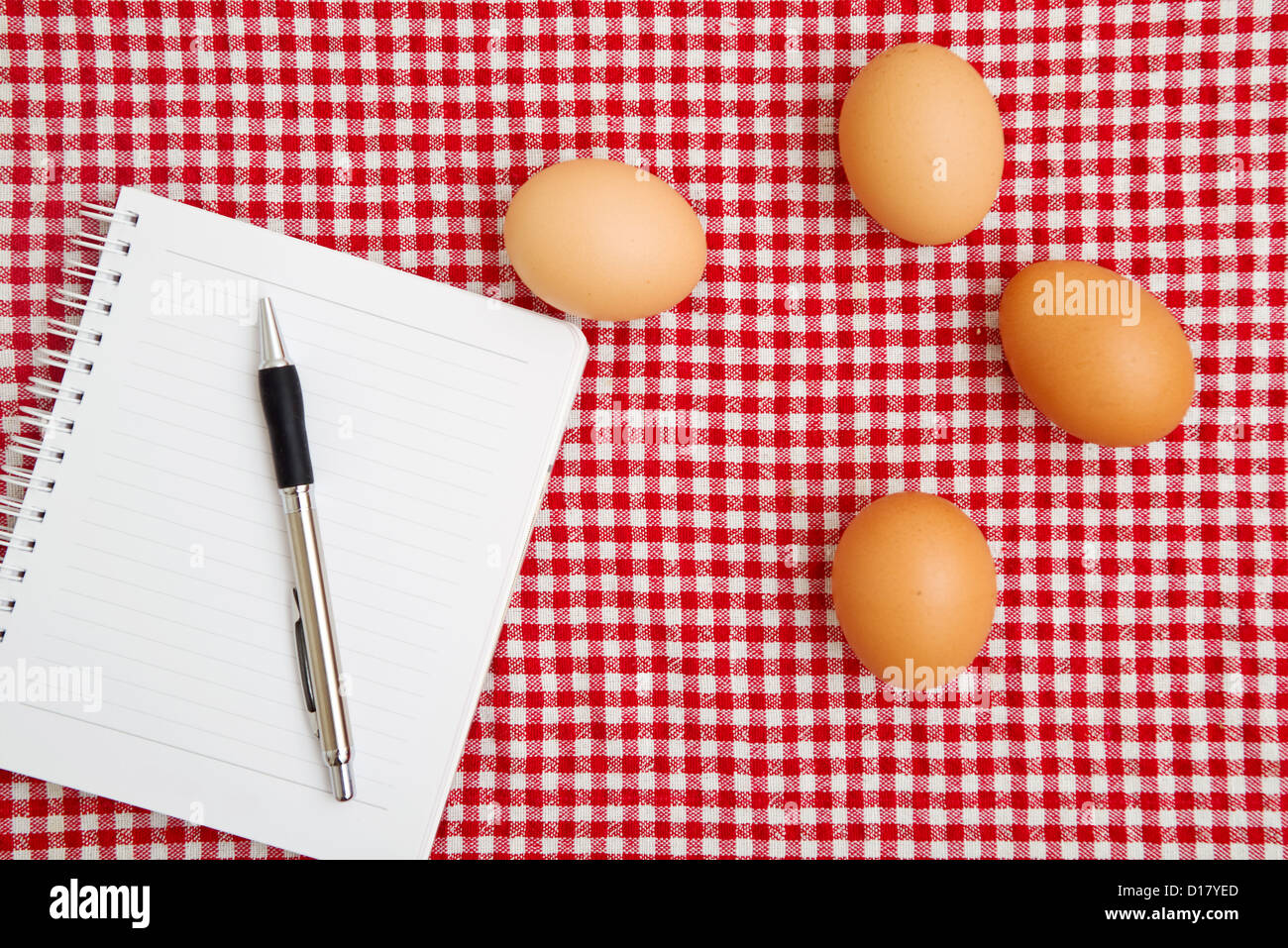 Uova di gallina sul tavolo con il rosso e bianco tovaglia a scacchi. Foto Stock