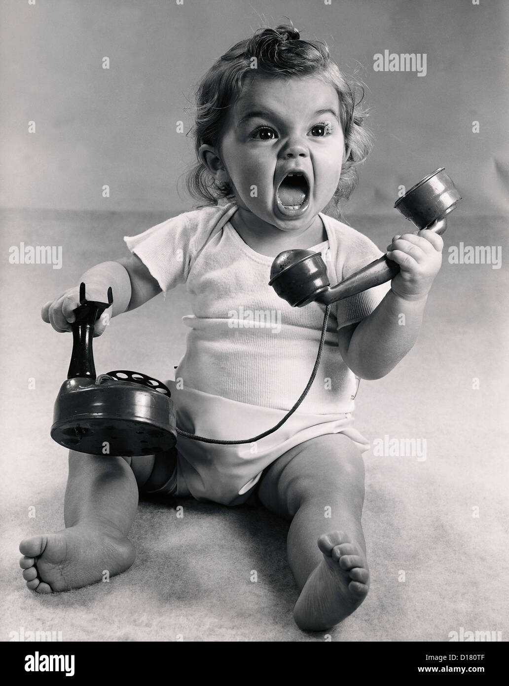 Foto d'epoca del neonato urlando con telefono Foto Stock