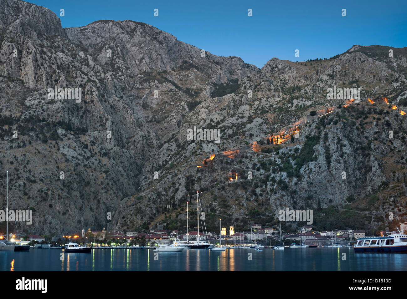 Vista del tramonto di Kotor Bay, città di Kotor e le fortificazioni che si affaccia sulla città in Montenegro. Foto Stock