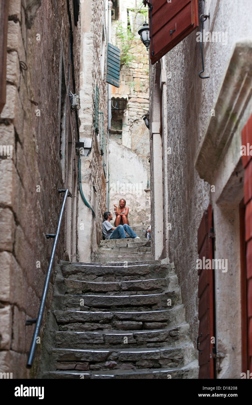 La gente seduta su una scala di pietra nella città vecchia di Kotor in Montenegro. Foto Stock