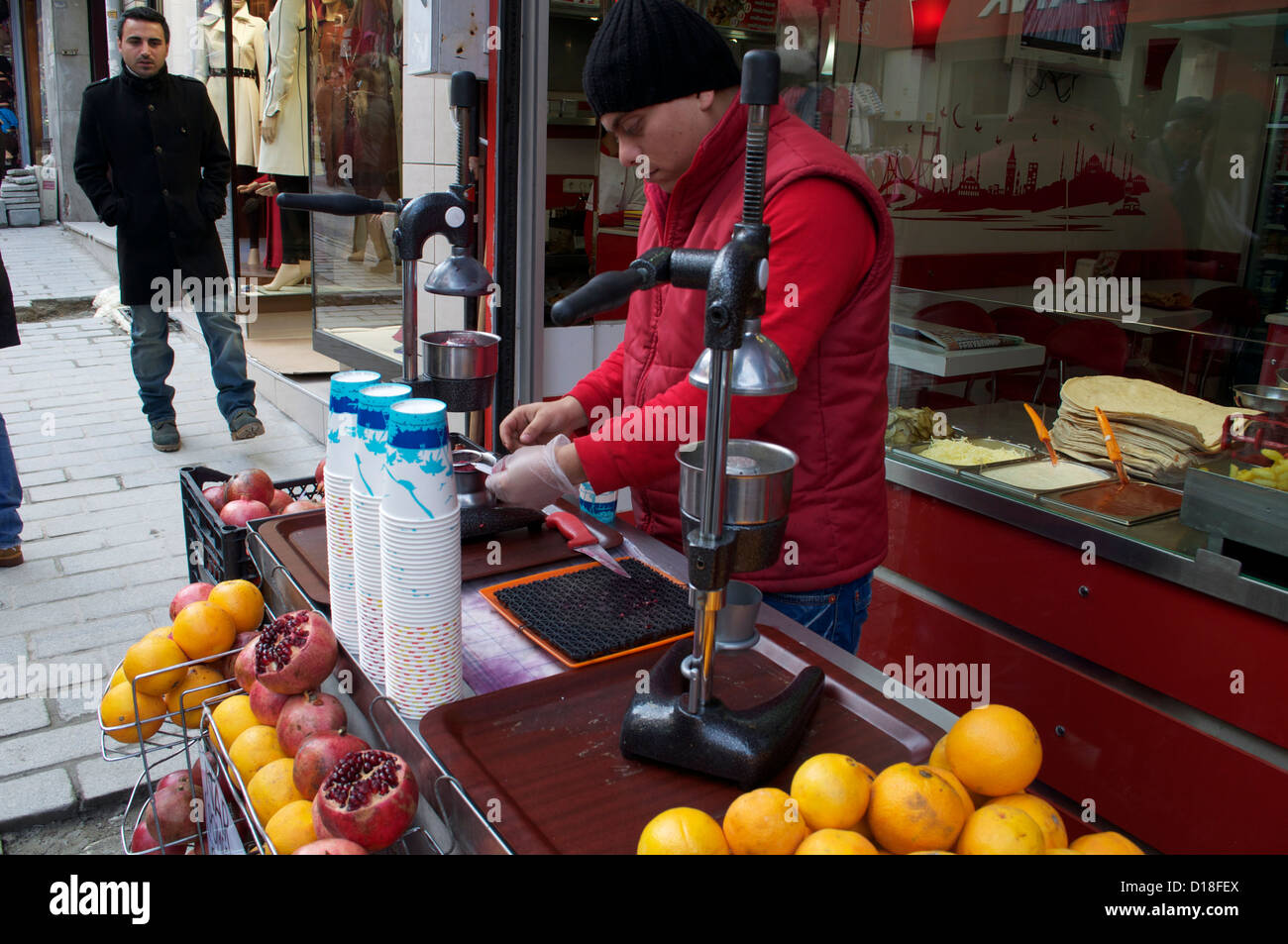 Il succo di melograno venditore in Istanbul Turchia premendo melograni freschi in un mercato Foto Stock
