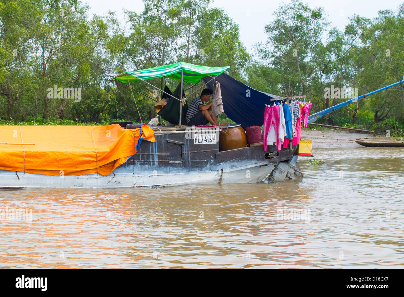 Un uomo su una barca nella regione del Delta del Mekong del Vietnam Foto Stock