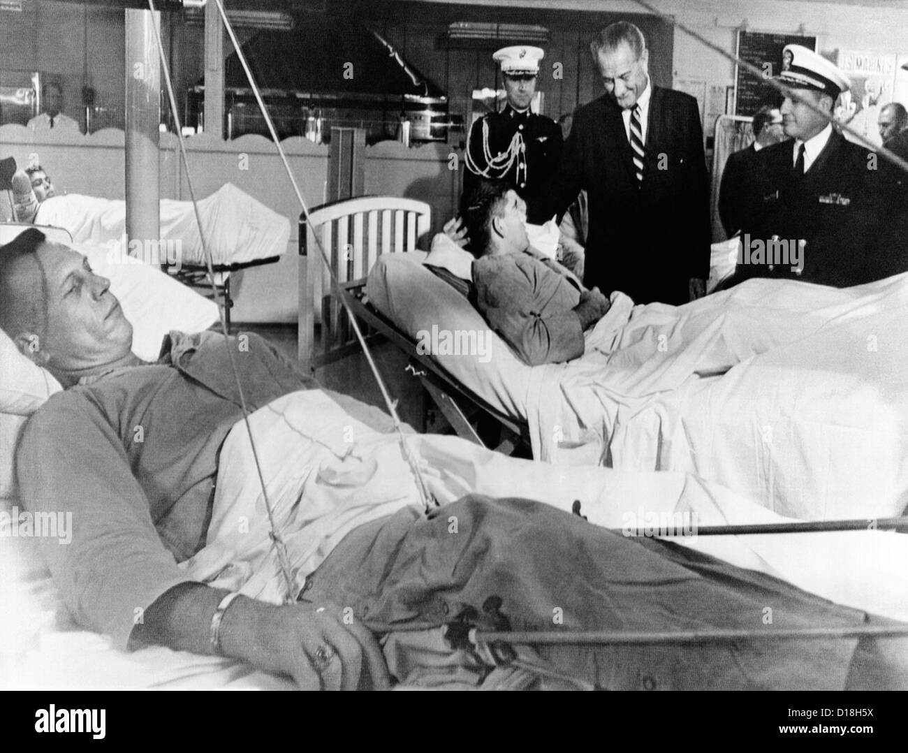 Il presidente Lyndon Johnson visite Vietnam feriti. Johnson chat con Cpl. Ronald Ortiz come 1Lt. Bernard VeRonin, giacente in Foto Stock